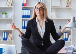 a young woman meditating in the office