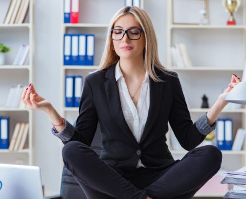 a young woman meditating in the office