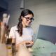 motivated woman in glasses sitting to do work