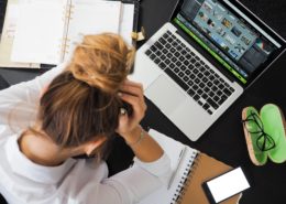 a woman struggling to do work on a laptop